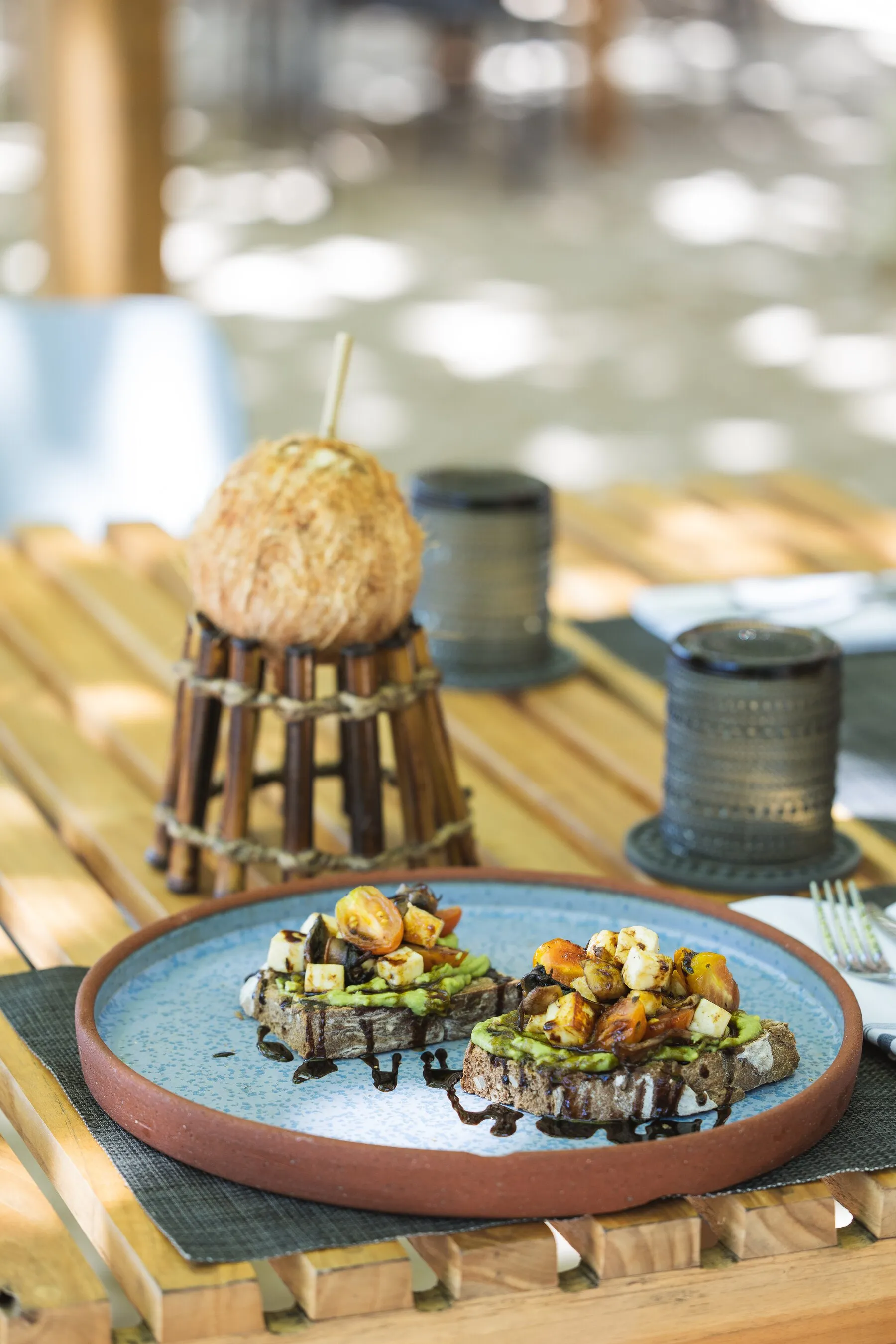 Avocado toast with grilled vegetables served by the ocean at Manzu