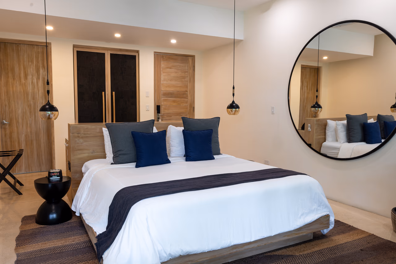 Manti Bungalow king bed, pendant lighting, and round wall mirror